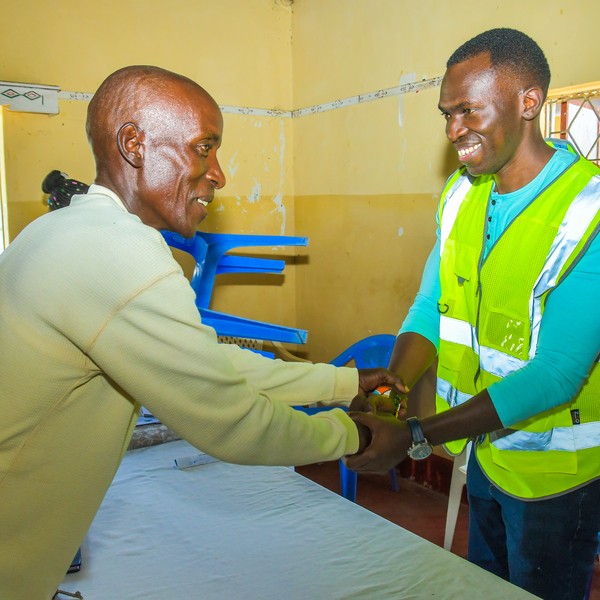 Trevor Ombija shaking hands with a man